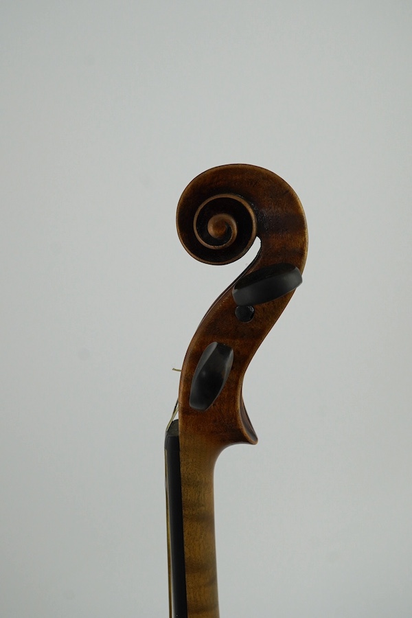 A late 19th century German Nuremberg school violin c.1880, Stradivarius pattern with a finely carved scroll and a large 14.25 inch body, together with a fully mounted German octagonal bow, contained within a contemporary